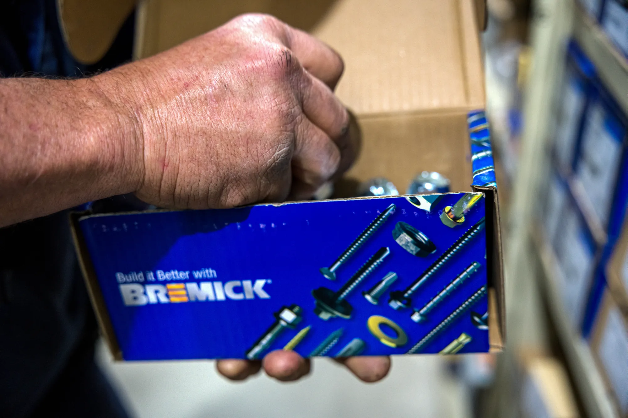 Hand picking bolts from an open Bremick box