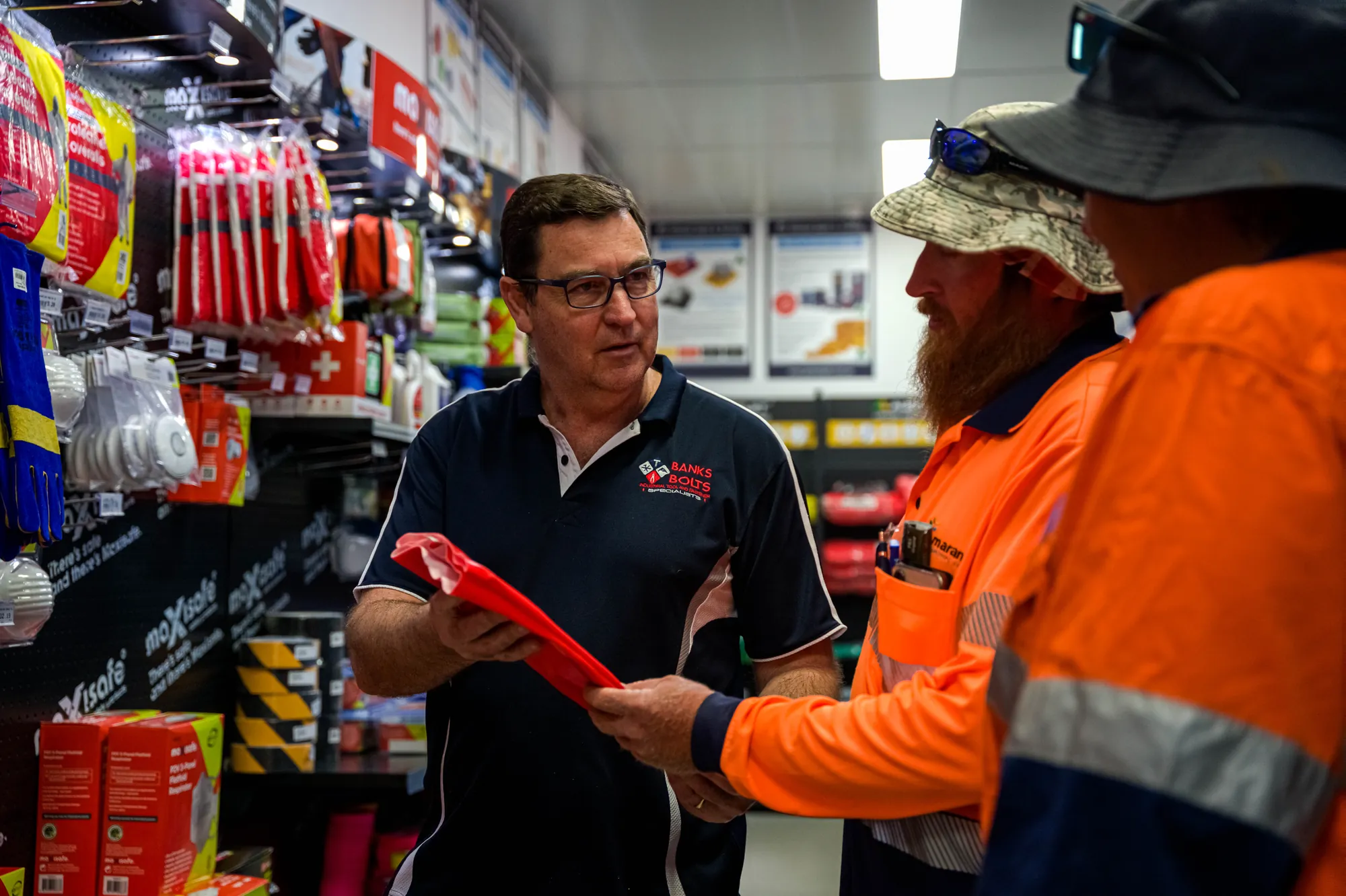 Staff member handing a product to a tradie in the Kincrome aisle