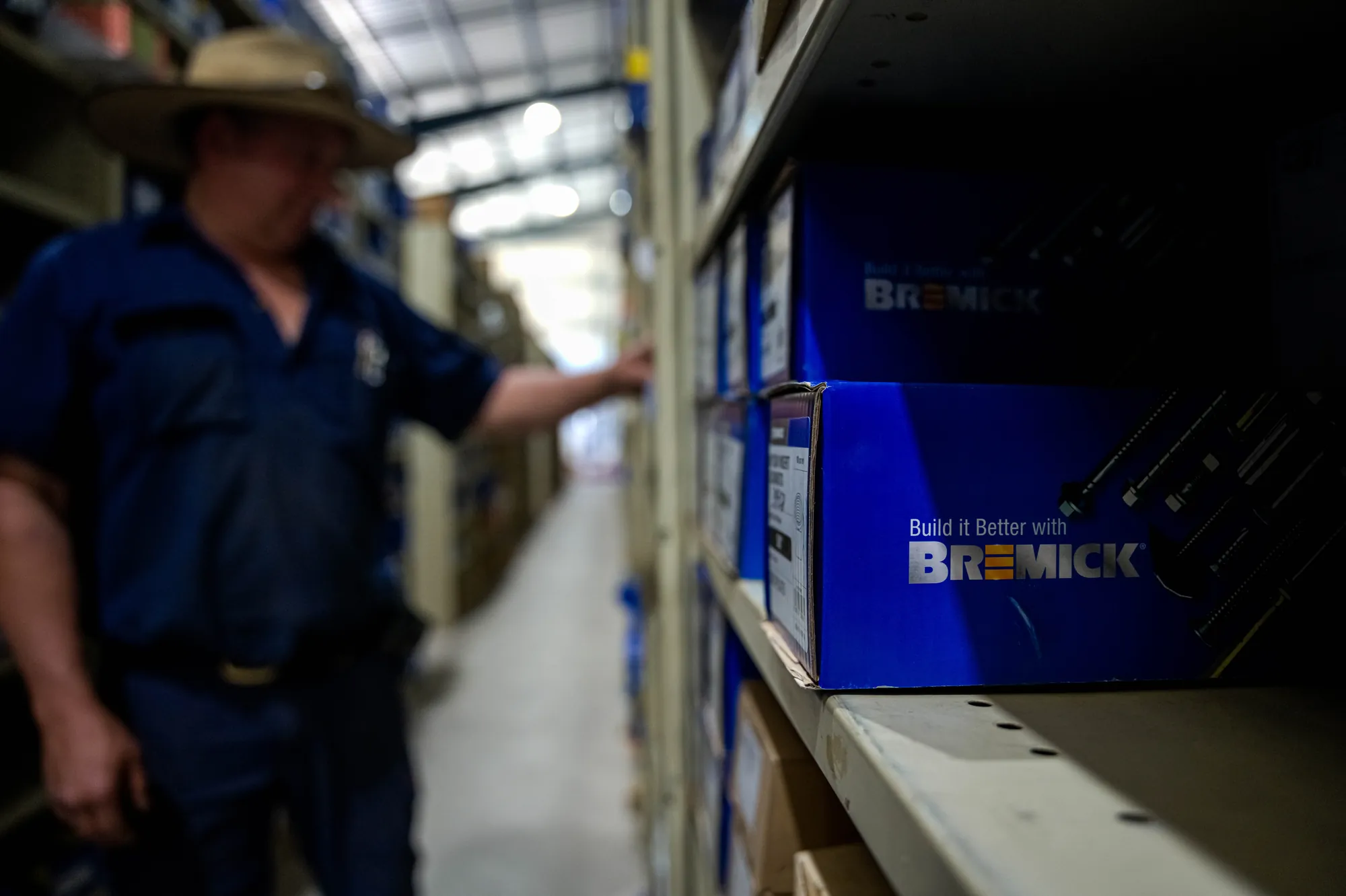 Staff member in the warehouse aisle beside Bremick fastener boxes